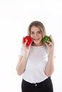 A close up of young and smiling woman who is holding red and green bell peppers. Healthy diet and vitamins. Vegetarian food. Royalty Free Stock Photo