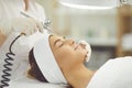 Woman getting oxygen therapy or jet peeling from cosmetologist