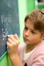 Close up of young student writing on chalkboard