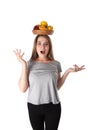 Close up of young surprised woman which is holding a wooden bowl with fruits: apples, oranges, lemon. Vitamins and healthy eating. Royalty Free Stock Photo