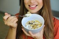 Close up of young unrecognizable woman eating skyr yogurt with cereal muesli fruit at home, focus on the muesli bowl, indoor Royalty Free Stock Photo