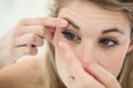 Close-up of young woman applying contact lens Royalty Free Stock Photo