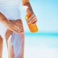 Closeup on young woman applying sun block creme on beach Royalty Free Stock Photo