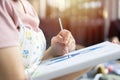 Close up of young woman artist painting with oil paint and a brush on paper or canvas Royalty Free Stock Photo