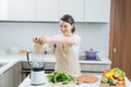 close up of young woman with blender and green vegetables making detox shake or smoothie at home Royalty Free Stock Photo