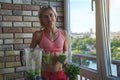 Close up of young woman with blender and green vegetables making detox shake or smoothie at home Royalty Free Stock Photo