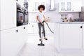 Woman Cleaning Kitchen Floor With Vacuum Cleaner Royalty Free Stock Photo