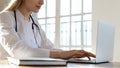 Close up young woman doctor working on laptop in hospital office Royalty Free Stock Photo