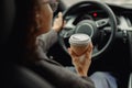 Close up of young woman drinking take out coffee when driving to work in car Royalty Free Stock Photo