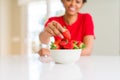 Close up of young woman eating fresh strawberries Royalty Free Stock Photo