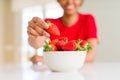 Close up of young woman eating fresh strawberries Royalty Free Stock Photo