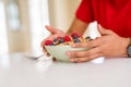 Close up of young woman eating healthy cereals and berries for breakfast Royalty Free Stock Photo