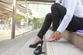 Close-up young woman feeling pain in her foot on stair, Have ankle pain, Health concept