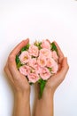 Close up of young woman florist hand creating bouquet of pink roses on a light Royalty Free Stock Photo