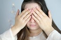 Close-up of a young woman, a girl with long hair, covering her face with her hands, the concept of awakening, hiding, not looking Royalty Free Stock Photo