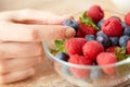 Close up of young woman hand with berries in bowl Royalty Free Stock Photo