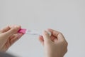 Close-up of young woman hand holding pregnancy test on white background. Royalty Free Stock Photo