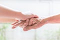 Close up of young woman hand holding with tenderness an elderly