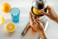 Close up of young woman hands doing fresh lemonade, squeezing juice from citrus fruit, juicer Royalty Free Stock Photo