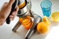 Close up of young woman hands doing fresh lemonade, squeezing juice from citrus fruit, juicer Royalty Free Stock Photo