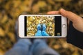 Close up of a young woman hands together holding a modern technology smartphone and taking a selfie picture of her legs and feet i Royalty Free Stock Photo