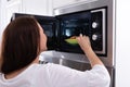 Woman Heating Fried Food In Microwave Oven Royalty Free Stock Photo