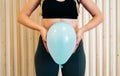 Close up of a young woman holding a balloon to explain the diaphragm zones, core and pelvic floor. Pelvic floor exercises