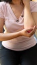 Close-up of a young woman holding her wrist with a red note of elbow pain. Looking at the concept of medical therapy