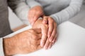 Close up of young woman holding senior man hands Royalty Free Stock Photo