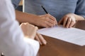 Close up of young woman job applicant signing employment contract