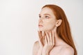 Close-up of young woman with long ginger hair, standing in profile and looking up with blue eyes, standing naked with Royalty Free Stock Photo