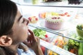 Young Woman Looking At Food In Refrigerator Royalty Free Stock Photo