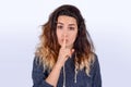 Close up of young woman making silence gesture Royalty Free Stock Photo