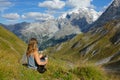 CLOSE UP: Young woman petting cute dog while observing the snowy mountains. Royalty Free Stock Photo