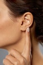 Close up of young woman pointing finger to her ear Royalty Free Stock Photo