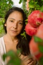 Young woman posing with ripe red pomegranates tree. concept of healthy autumn and winter lifestyle and diet, outdoors with nature