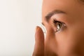 Close up of a young woman putting contact lens in her eye close up Royalty Free Stock Photo