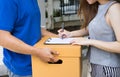 Close up young woman putting signature in clipboard receipt of d Royalty Free Stock Photo