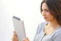 Close up of a young woman reading a tablet reader outdoors