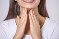 Close up of young woman rubbing her inflamed tonsils, tonsilitis problem, cropped. Woman with thyroid gland problem, touching her