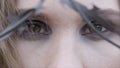 Close-up of a young woman`s eyes through barbed wire. Action. Beauty fashion concept