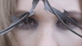 Close-up of a young woman`s eyes through barbed wire. Action. Beauty fashion concept