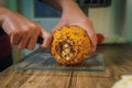 Young Woman cutting a pineapple on a wooden table in the kitchen Royalty Free Stock Photo