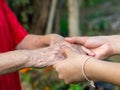 Close-up of a young woman`s hands holding an elderly female`s hands. Concept of aged people and healthcare Royalty Free Stock Photo