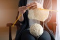 Close up on young woman's hands knitting