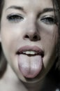 Close up of young woman sticking out tongue. Royalty Free Stock Photo