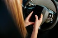 Close Up Of Young Woman Texting On Mobile Phone Whilst Driving Car