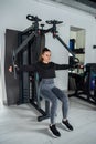 close-up young woman trains muscles on exercise machine in the gym. Royalty Free Stock Photo