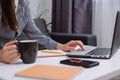 Close up of young woman using laptop, sitting on couch, female hands typing, writing notes, studying languages, checking email in Royalty Free Stock Photo