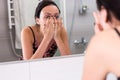 Close up young woman washing face standing in front of mirror Royalty Free Stock Photo